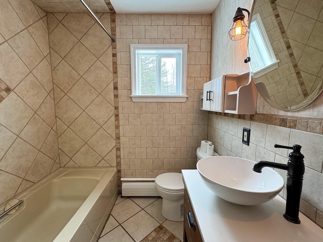 full bathroom featuring baseboard heating, tile patterned flooring, toilet, vanity, and tile walls