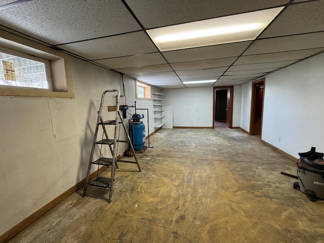 basement featuring a drop ceiling and a healthy amount of sunlight