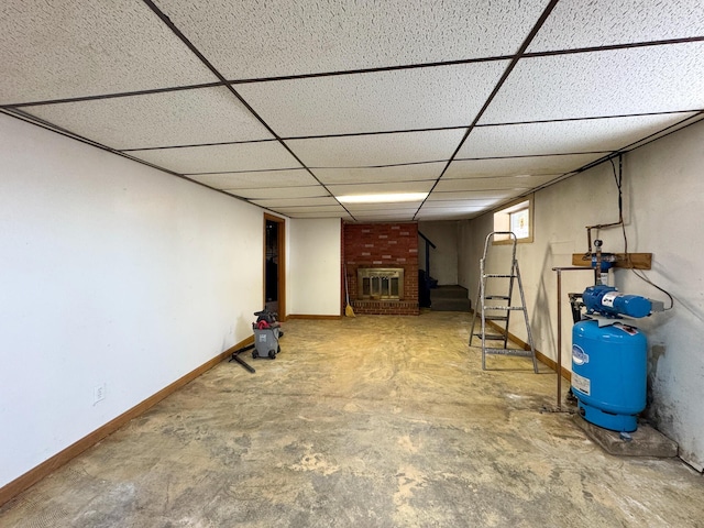 basement featuring a fireplace and a drop ceiling