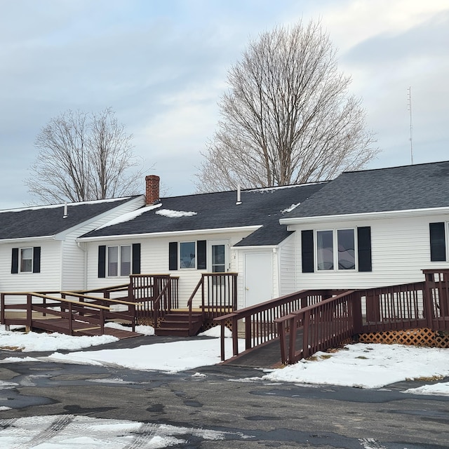 snow covered rear of property featuring a wooden deck