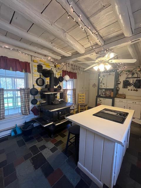 kitchen featuring a wealth of natural light, a kitchen bar, white cabinets, and a center island