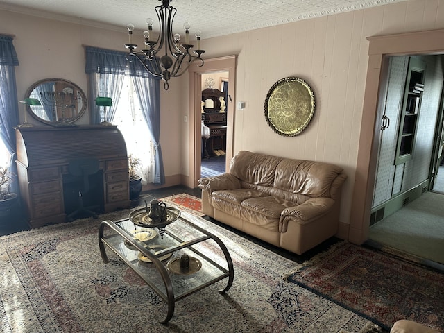 living room featuring a notable chandelier, wood walls, a textured ceiling, and ornamental molding