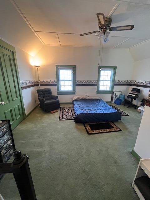 carpeted bedroom featuring ceiling fan, multiple windows, and lofted ceiling