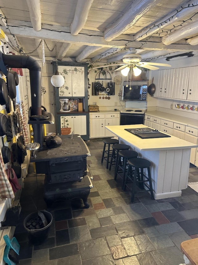 kitchen featuring white cabinetry, range with electric stovetop, ceiling fan, black electric cooktop, and beam ceiling