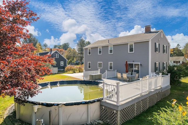 rear view of house featuring a swimming pool side deck