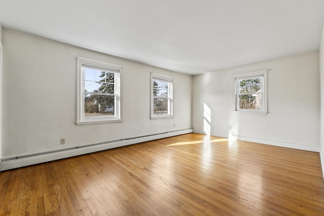 empty room with light wood-type flooring and a baseboard radiator