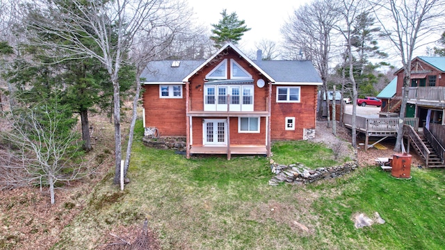 rear view of house with a yard and a deck