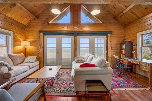 living room with french doors, wooden walls, wood-type flooring, built in desk, and beamed ceiling