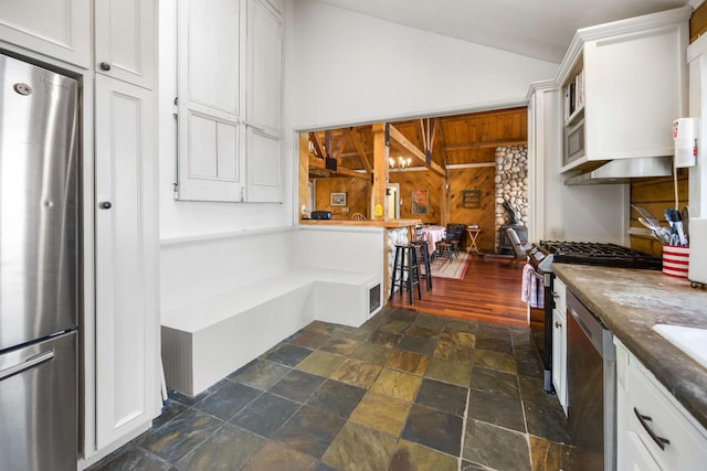 kitchen featuring white cabinets, appliances with stainless steel finishes, and vaulted ceiling