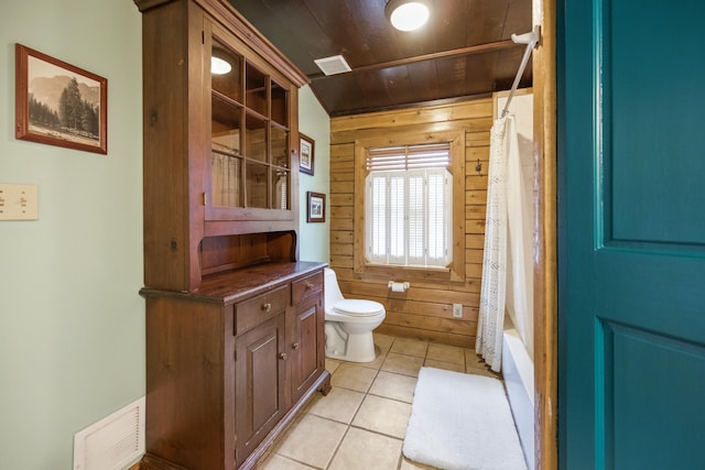 full bathroom featuring wood ceiling, tile patterned flooring, toilet, wooden walls, and shower / tub combo with curtain