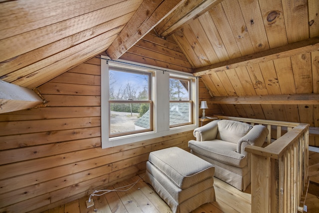 interior space with light wood-type flooring, wood walls, lofted ceiling with beams, and wooden ceiling