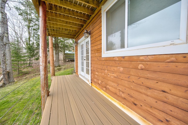 wooden terrace featuring french doors and a lawn