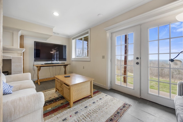 living room with french doors, a tile fireplace, light tile patterned floors, and plenty of natural light