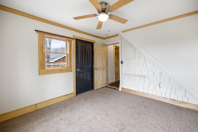 carpeted spare room featuring ceiling fan and crown molding