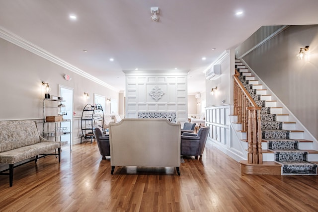 living room featuring a wall mounted air conditioner, crown molding, and hardwood / wood-style floors