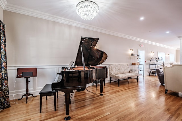 living area featuring light hardwood / wood-style flooring, crown molding, and a chandelier