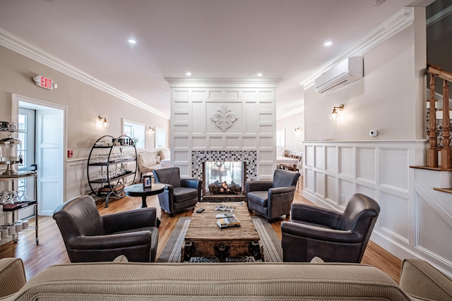 living room featuring light hardwood / wood-style floors, ornamental molding, and a wall mounted air conditioner