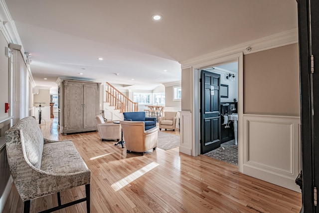 living room with ornamental molding and light hardwood / wood-style floors