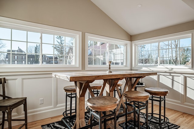 dining room with lofted ceiling and light hardwood / wood-style flooring