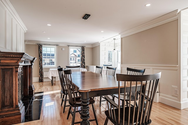 dining space featuring ornamental molding and light hardwood / wood-style floors