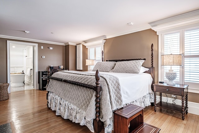 bedroom featuring multiple windows, connected bathroom, and crown molding