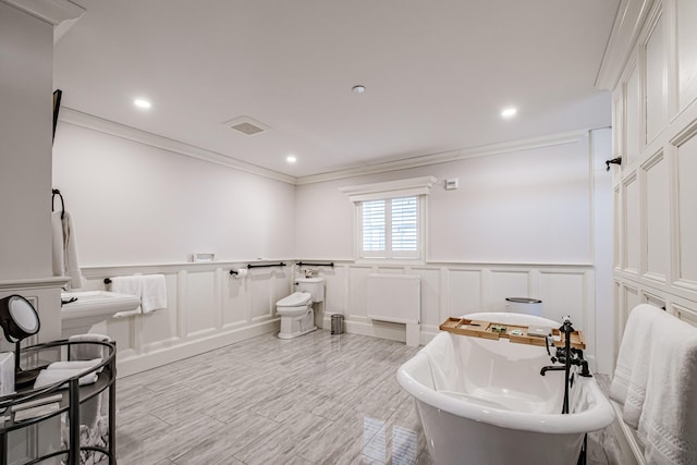 bathroom featuring crown molding, a bathtub, and radiator heating unit