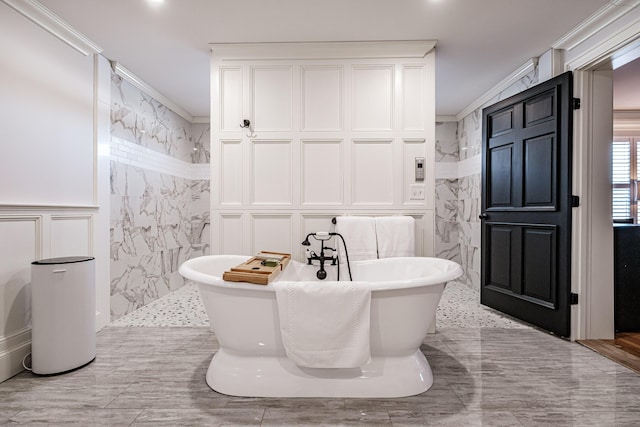 bathroom featuring tile walls, ornamental molding, and a bath