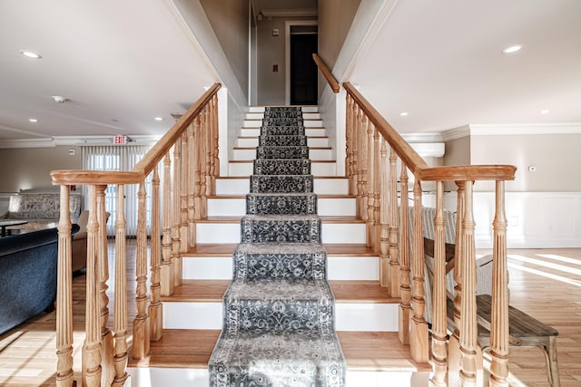 staircase with a wall mounted air conditioner, crown molding, and hardwood / wood-style flooring