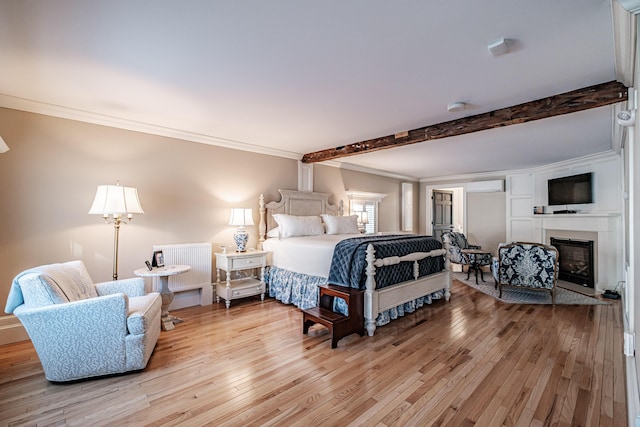 bedroom featuring beam ceiling, a wall unit AC, ornamental molding, and light hardwood / wood-style floors