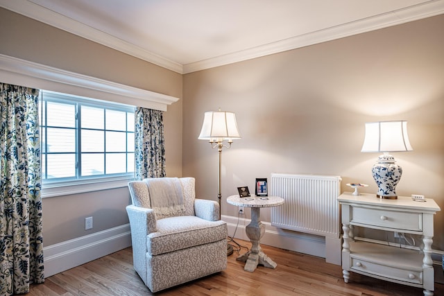 living area featuring radiator, ornamental molding, and light hardwood / wood-style flooring