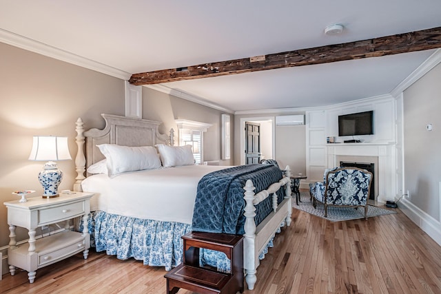 bedroom featuring light hardwood / wood-style flooring, crown molding, and a wall mounted AC