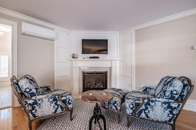 sitting room featuring crown molding, light hardwood / wood-style flooring, and a wall mounted air conditioner