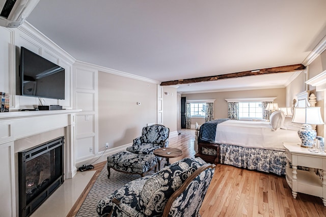 bedroom featuring crown molding, light hardwood / wood-style floors, and beamed ceiling