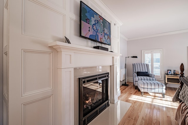 living room with ornamental molding and light hardwood / wood-style flooring