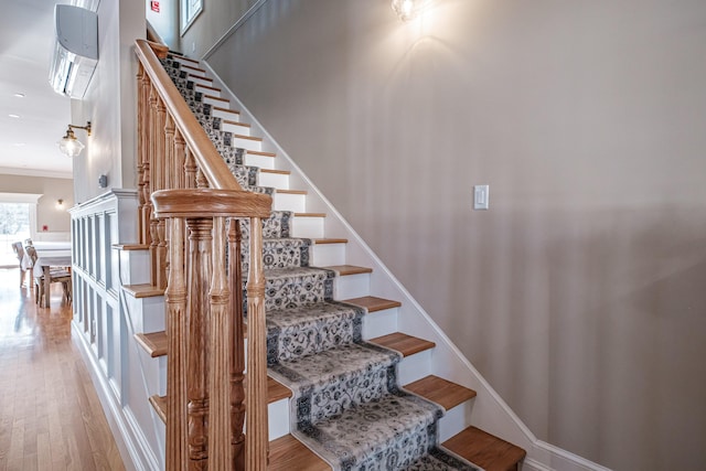 stairs featuring crown molding and wood-type flooring