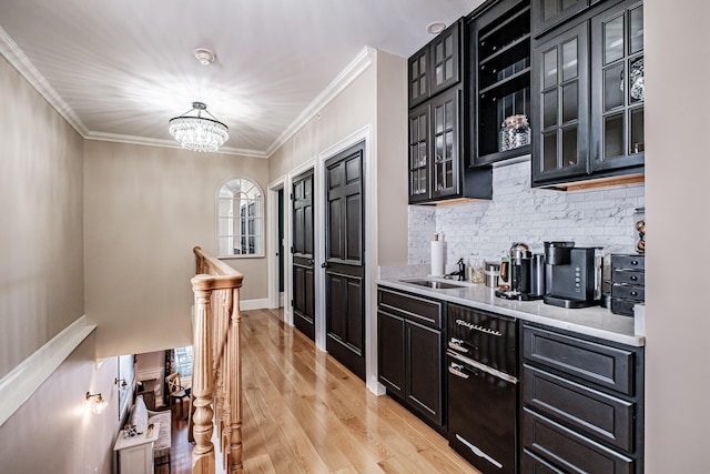 bar with light hardwood / wood-style floors, backsplash, hanging light fixtures, a chandelier, and sink