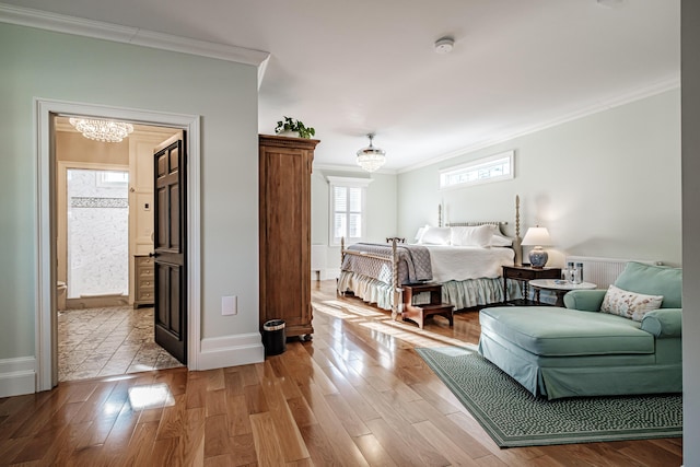 bedroom with light hardwood / wood-style floors, ornamental molding, and an inviting chandelier