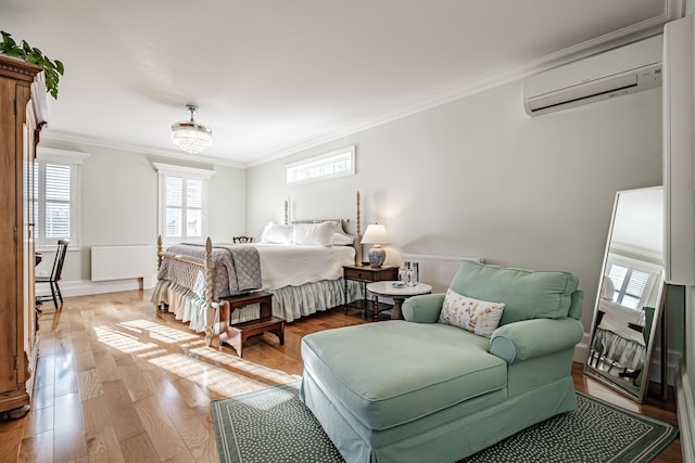 bedroom with radiator heating unit, light hardwood / wood-style floors, a chandelier, a wall mounted AC, and crown molding