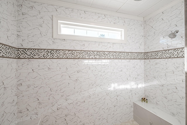 bathroom with ornamental molding and a tile shower