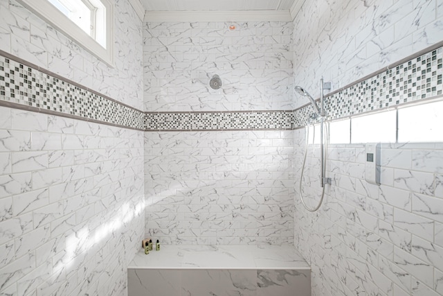 bathroom featuring ornamental molding, a healthy amount of sunlight, and tiled shower