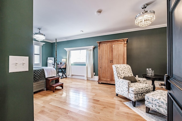 sitting room featuring a notable chandelier, ornamental molding, and light hardwood / wood-style flooring