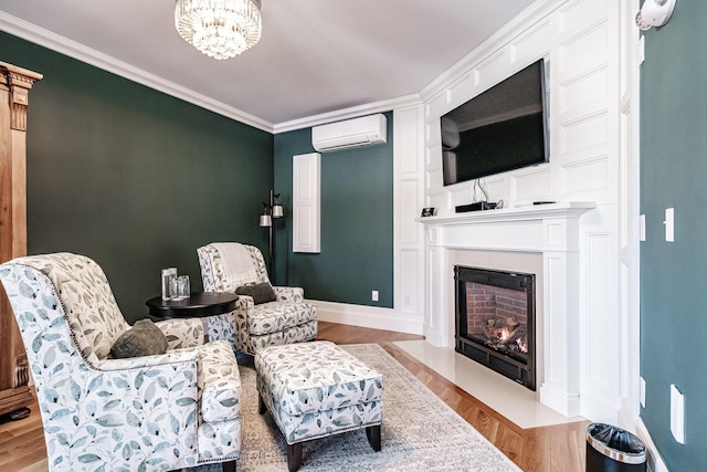 living area with a wall mounted AC, an inviting chandelier, ornamental molding, and light hardwood / wood-style floors