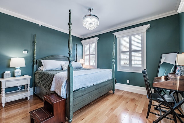 bedroom with ornamental molding, light hardwood / wood-style floors, and a chandelier