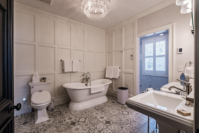 bathroom with sink, toilet, a bathing tub, and an inviting chandelier