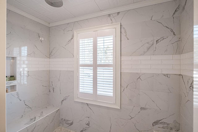 bathroom featuring crown molding and a tile shower