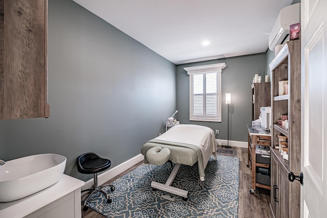 bedroom featuring wood-type flooring and an AC wall unit