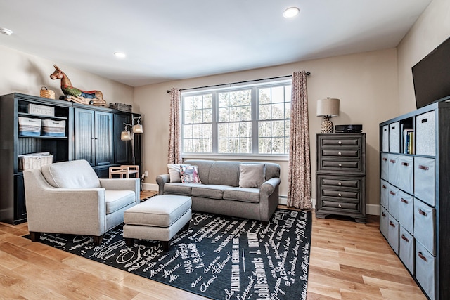 living room featuring a baseboard heating unit and light hardwood / wood-style flooring