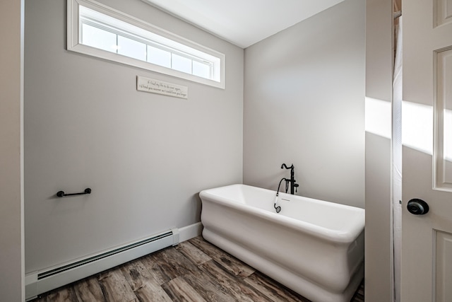 bathroom with a baseboard radiator, hardwood / wood-style floors, and a bathing tub