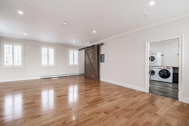 unfurnished living room with a baseboard heating unit, a barn door, and washer / clothes dryer