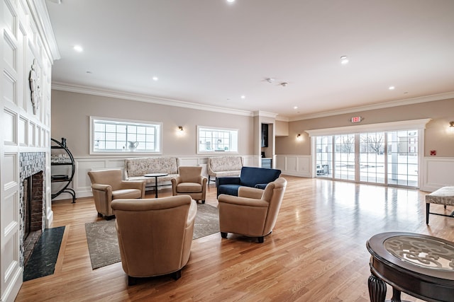 living room with light hardwood / wood-style floors, plenty of natural light, and ornamental molding